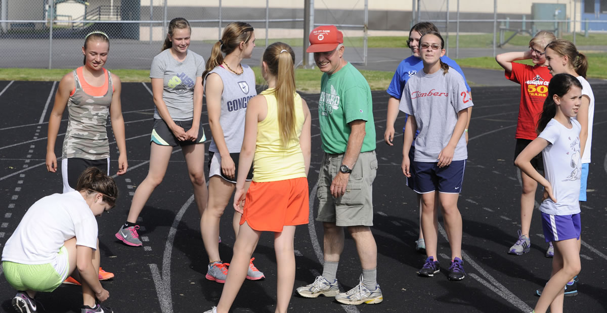 Bruce Flanagan, center, gathers the current edition of his long-running Flanagan Clan Girls Track Team for a workout last week in Woodland.