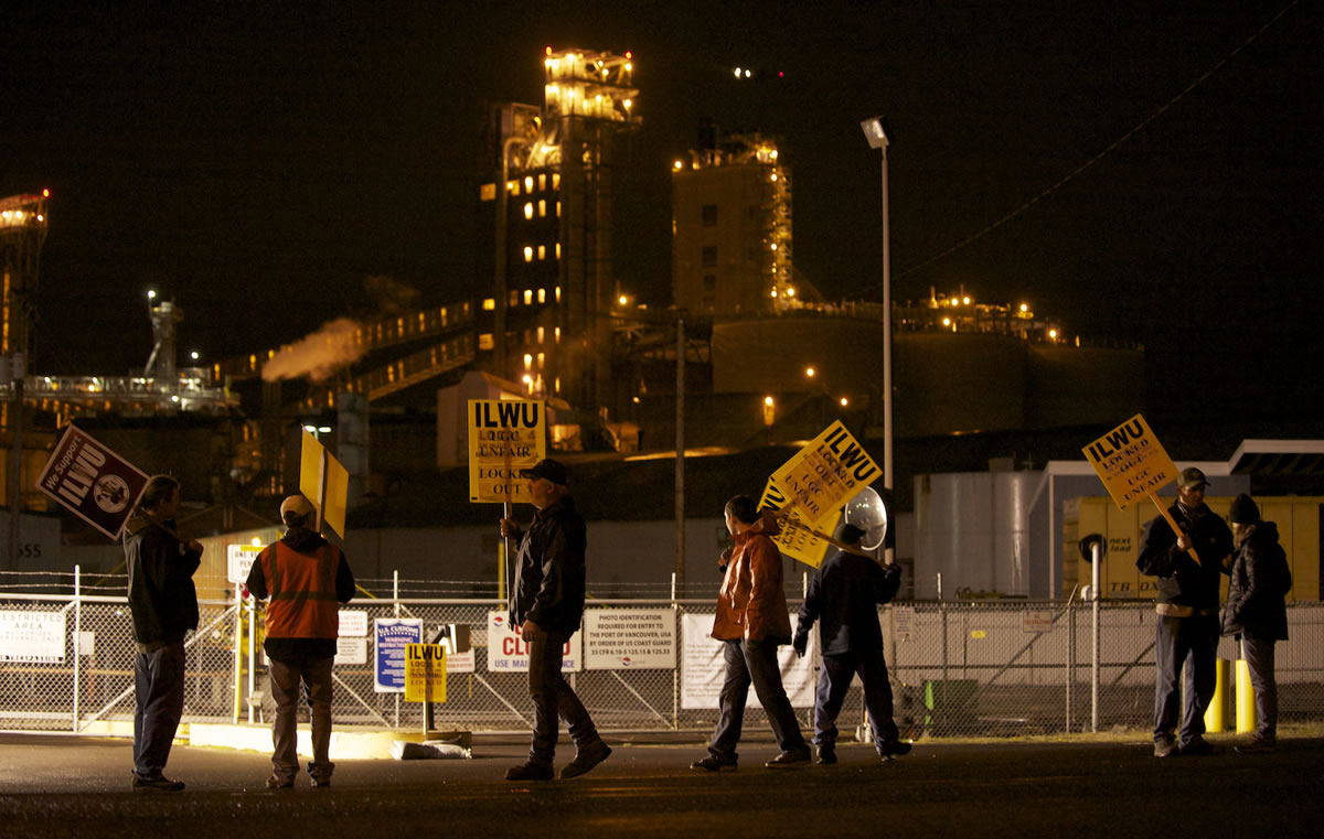 ILWU workers picket Wednesday evening in front of the Port of Vancouver's Gate 2 with grain terminals in the background.