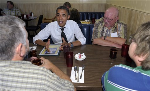 President Barack Obama visits with military veterans Dean Dilley, left, Mark Peterson, background, right, and Thomas Foeller, right, during a stop to the Gateway Breakfast House in Portland today.