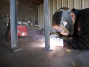 Aaron Crossley, a job supervisor for Phoenix Industrial, welds a stand for an electrical panel.