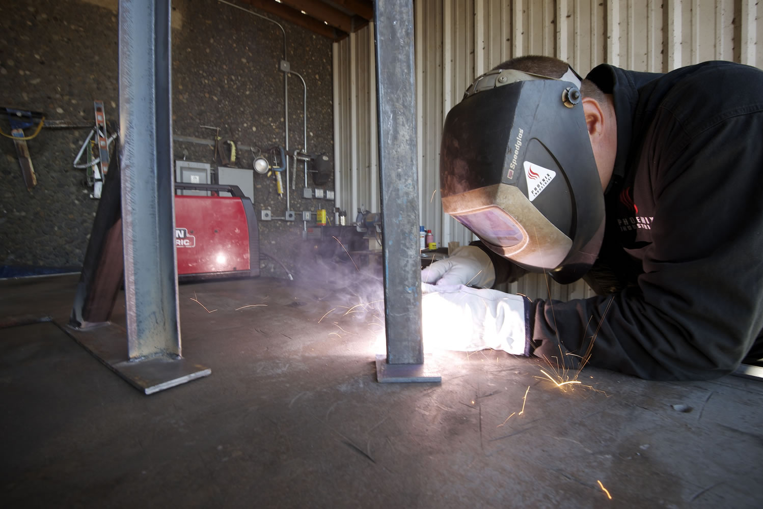 Aaron Crossley, a job supervisor for Phoenix Industrial, welds a stand for an electrical panel.