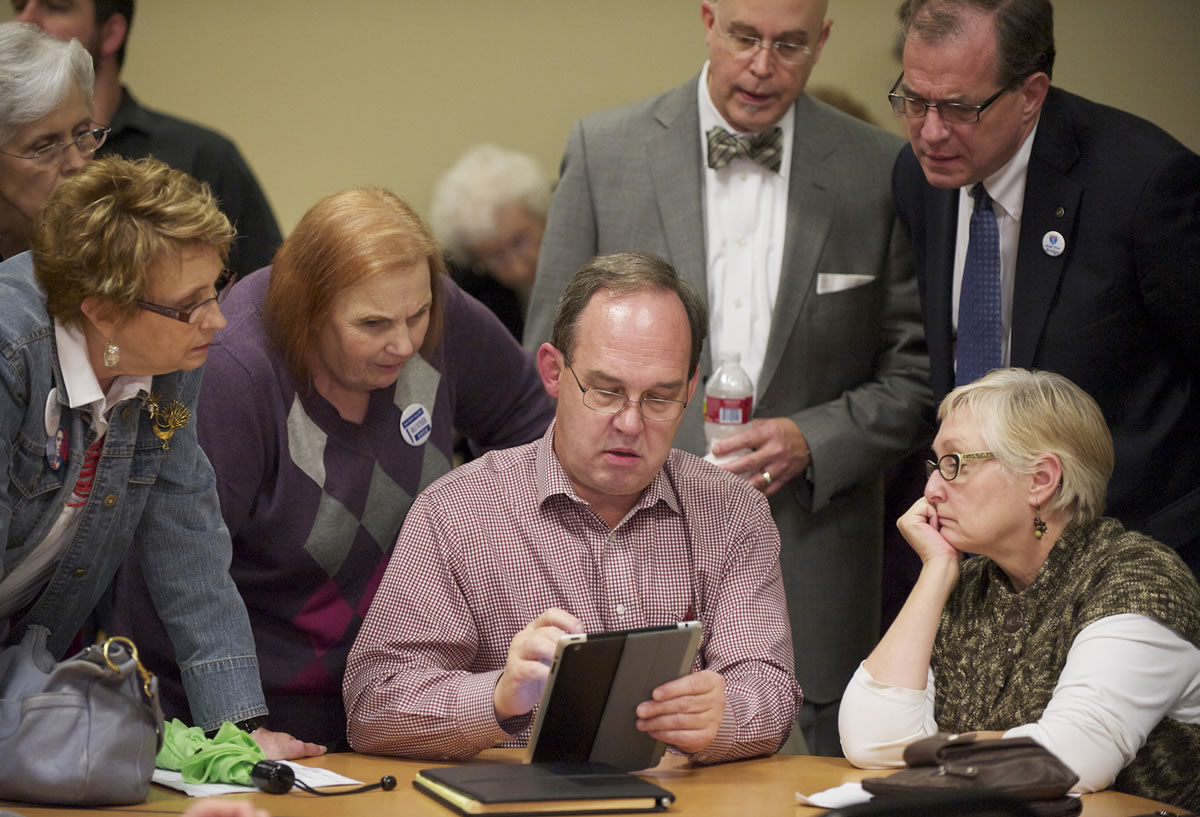 Vancouver City Councilor Jack Burkman, center, displays election results at Clark College's Gaiser Hall.