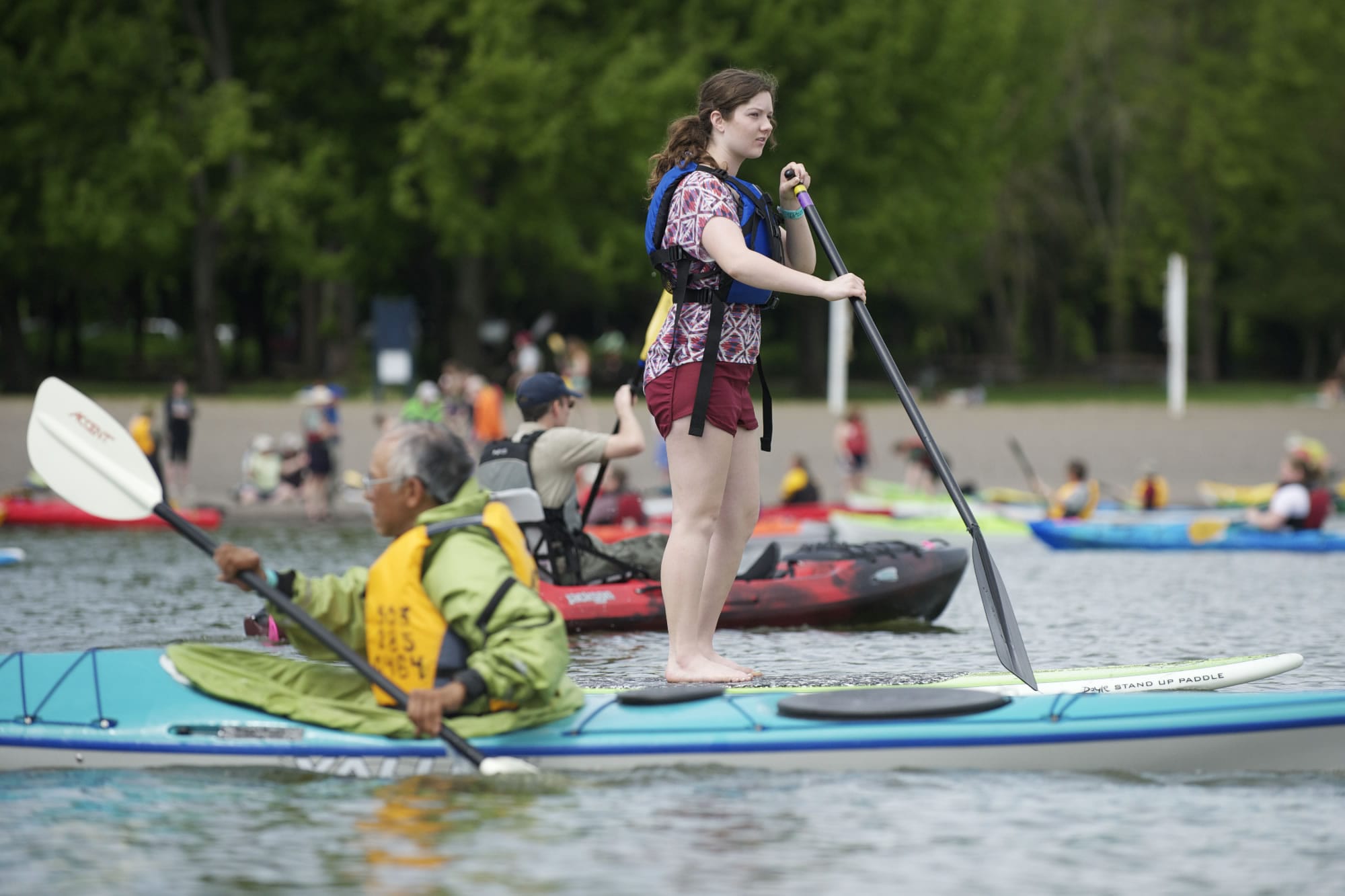 Jillian Cammer tries a stand-up paddle board at the 21st annual Spring Paddle Festival at Vancouver Lake on Saturday.