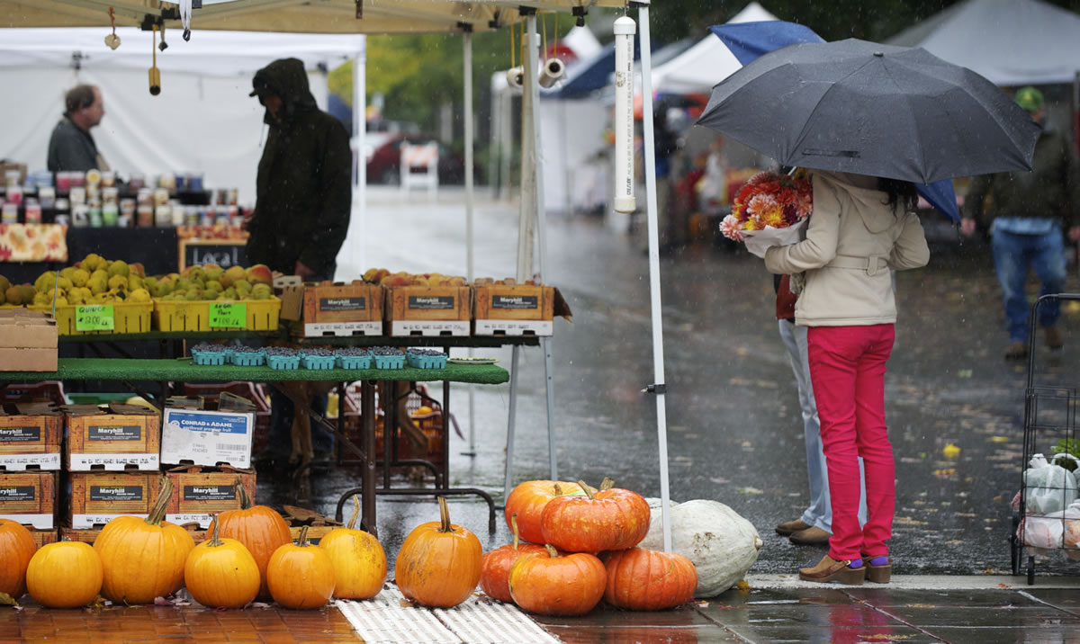 Mila Wood holds cut flowers on the soggy final day of the Vancouver Farmers Market's 2012 season on Sunday.