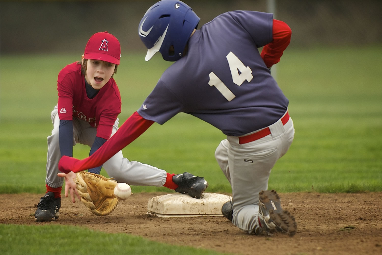 Angels shortstop Corbin Sarvela, 10, awaits the throw as Red Sox runner Cole Bain, 10, steals second base during Hazel Dell Little League's opening-day action.
