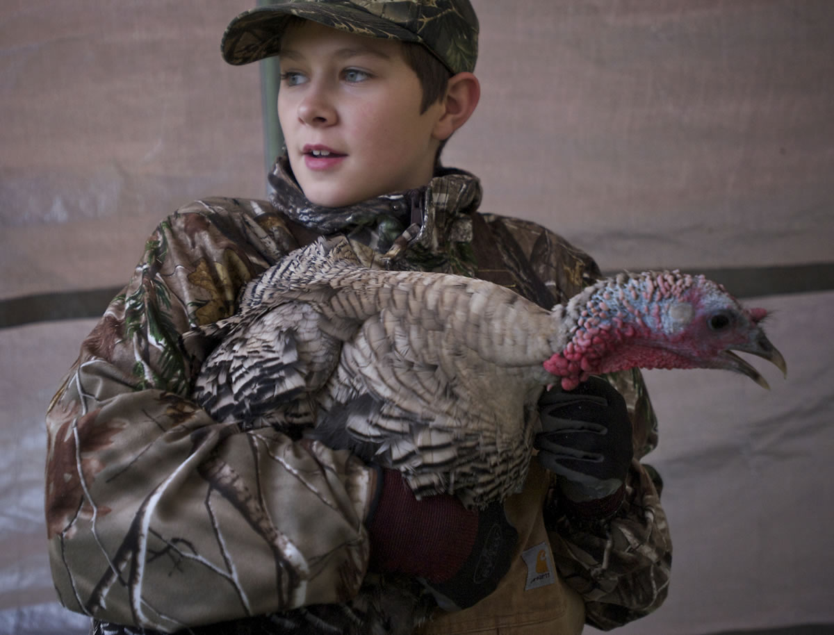 Connor McGuffin, 12, holds a prized bird at the family farm.