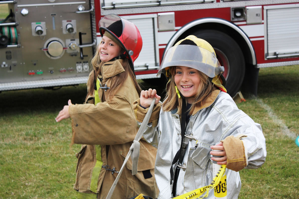 Warrenton, Ore.: Kiara Campbell-Burgess, left, and Kaylie Babcock, both from Vancouver, participate in a firefighting activity on July 30 while attending Camp Rosenbaum in Warrenton, Ore.