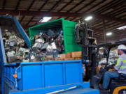 Dennis Collison of IMS Electronics Recycling dumps electronics components for recycling.