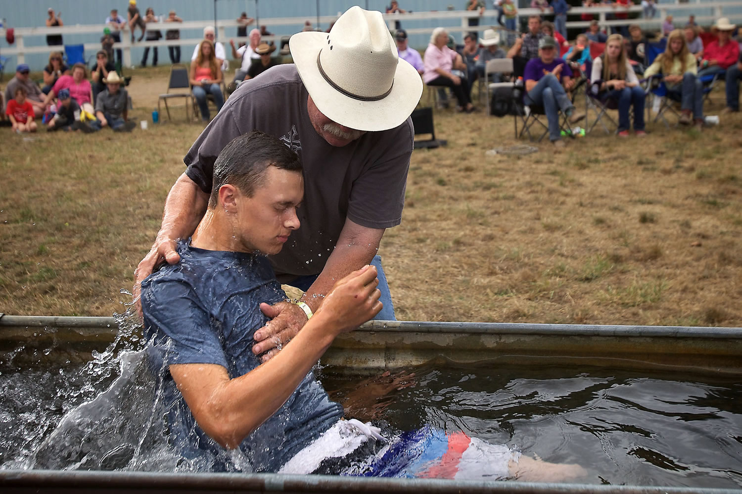 Using a horse trough, Larry Cutler baptizes Daniel Sage at the conclusion of the camp at the Vancouver Saddle Club on Aug. 15.