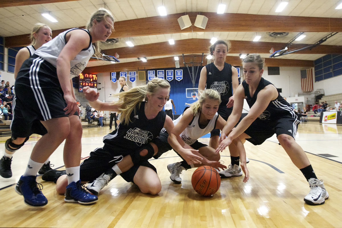 Players fight for a loose ball during the Les Schwab Roundball Shootout at Clark College.
