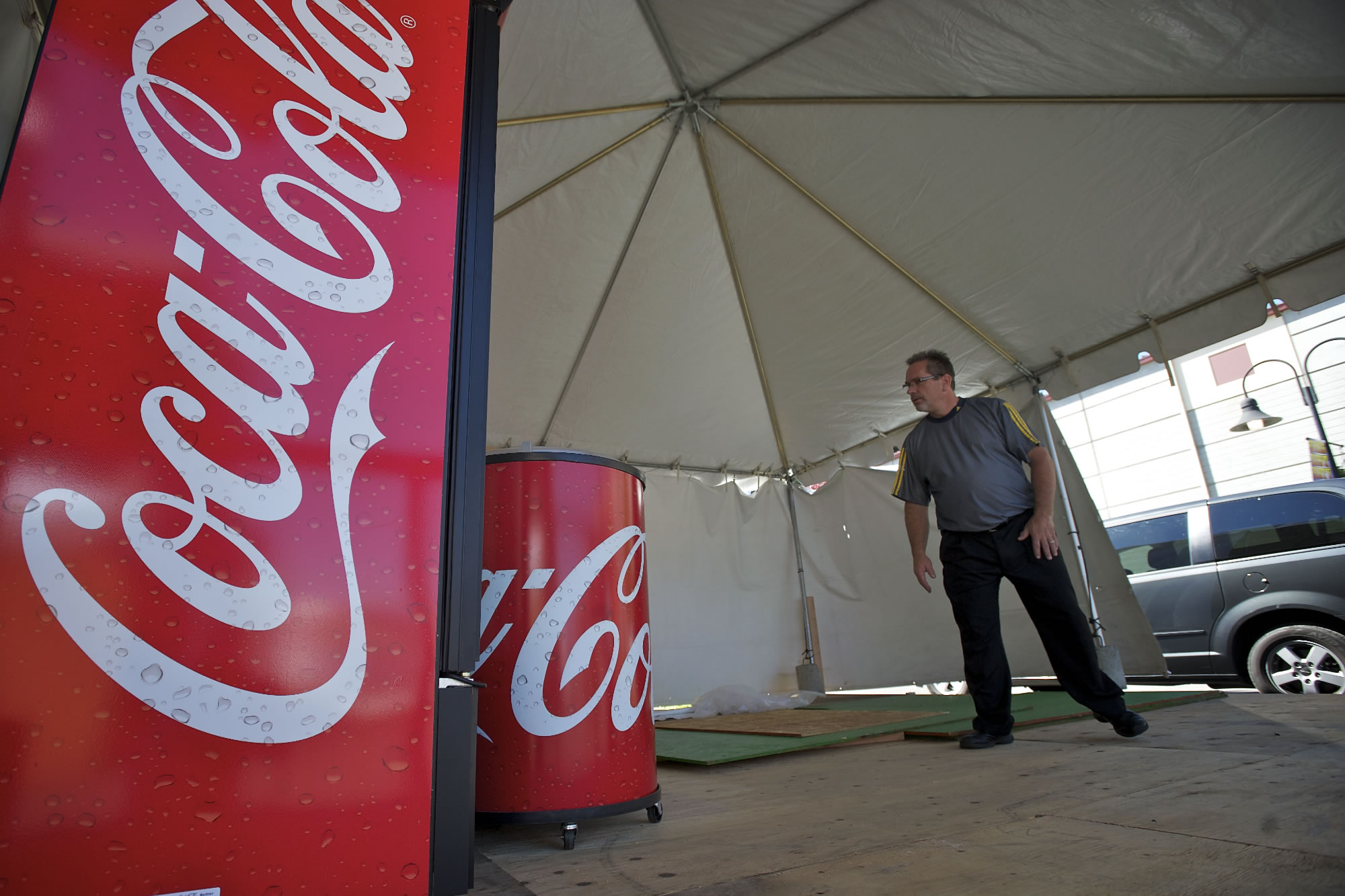 Greg Taylor looks over a booth filled with Coca-Cola products while in the process of setting up for the Clark County Fair.