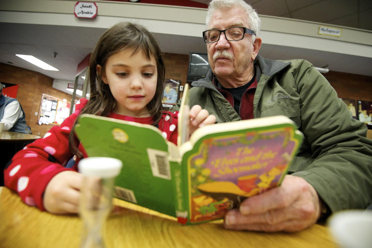 Volunteer Ralph Hutchison, right, reads a book to Abigail Potts, 6, a first-grade student at Peter S. Ogden Elementary School on Tuesday. Hutchison has been volunteering as a tutor for two years. &quot;It's very rewarding,&quot; Hutchison said.