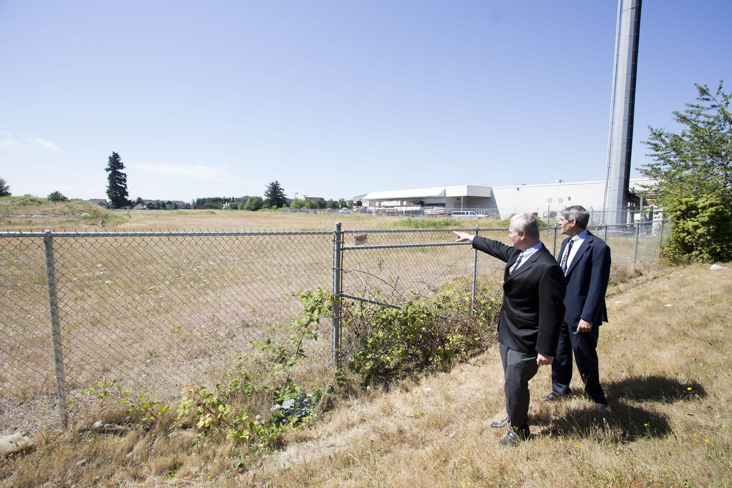 Troy Drawz, left, and Roy Johnson of the Vancouver Housing Authority look over the site where the VHA has proposed to build 152 units of low-income apartments, just east of 164th Avenue on Southeast First Street.