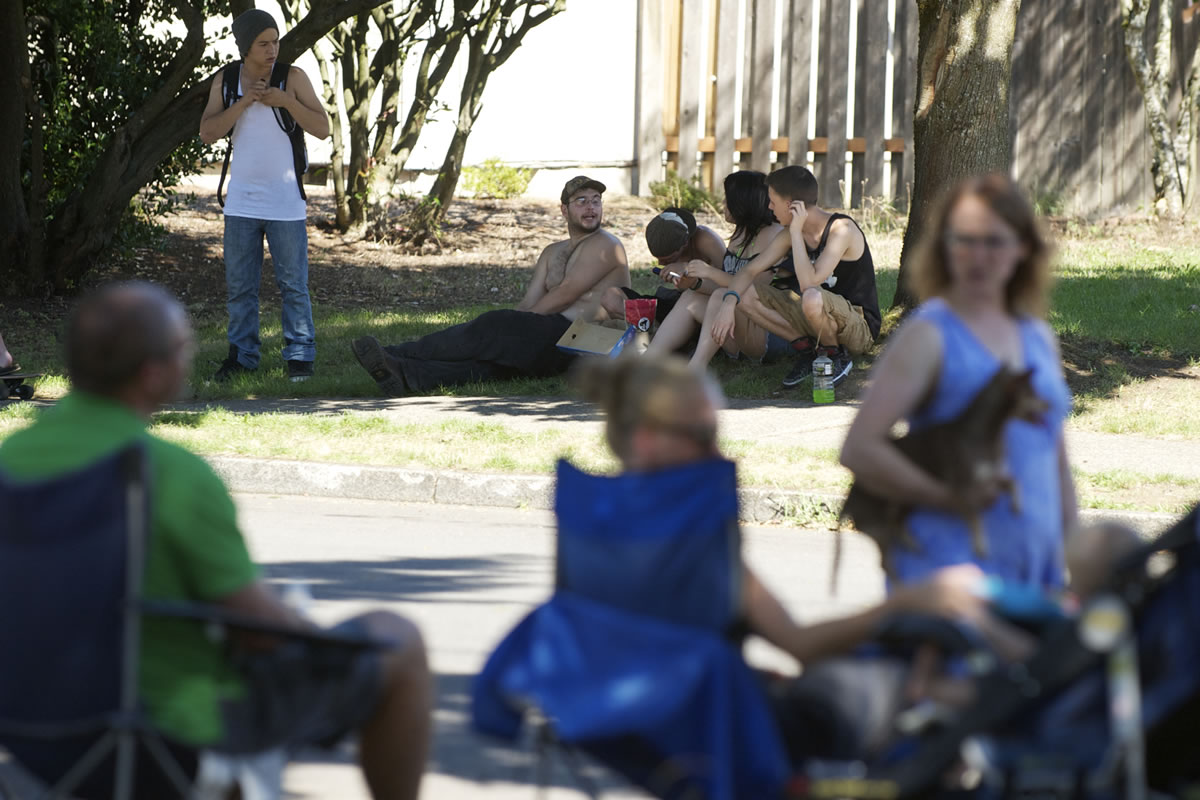 A group of adult residents monitor a group of teens who congregate on Southeast 147th Avenue near Mountain View High School.