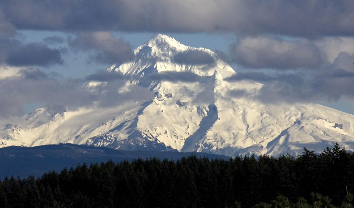 Clouds flit across the west face of Mount Hood as seen near Boring, Ore., in February 2010. An El Nino-like winter could put a dent in typical snow packs by spring.