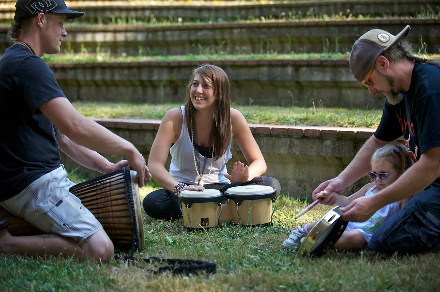 From left, Luke Alexander, 25, of Vancouver; Sarah Cayton; and Ray DeLorme, 38, of Woodland, with his daughter, Mackenzie, 2, participate in a drum circle at Water Works Park on Wednesday.
