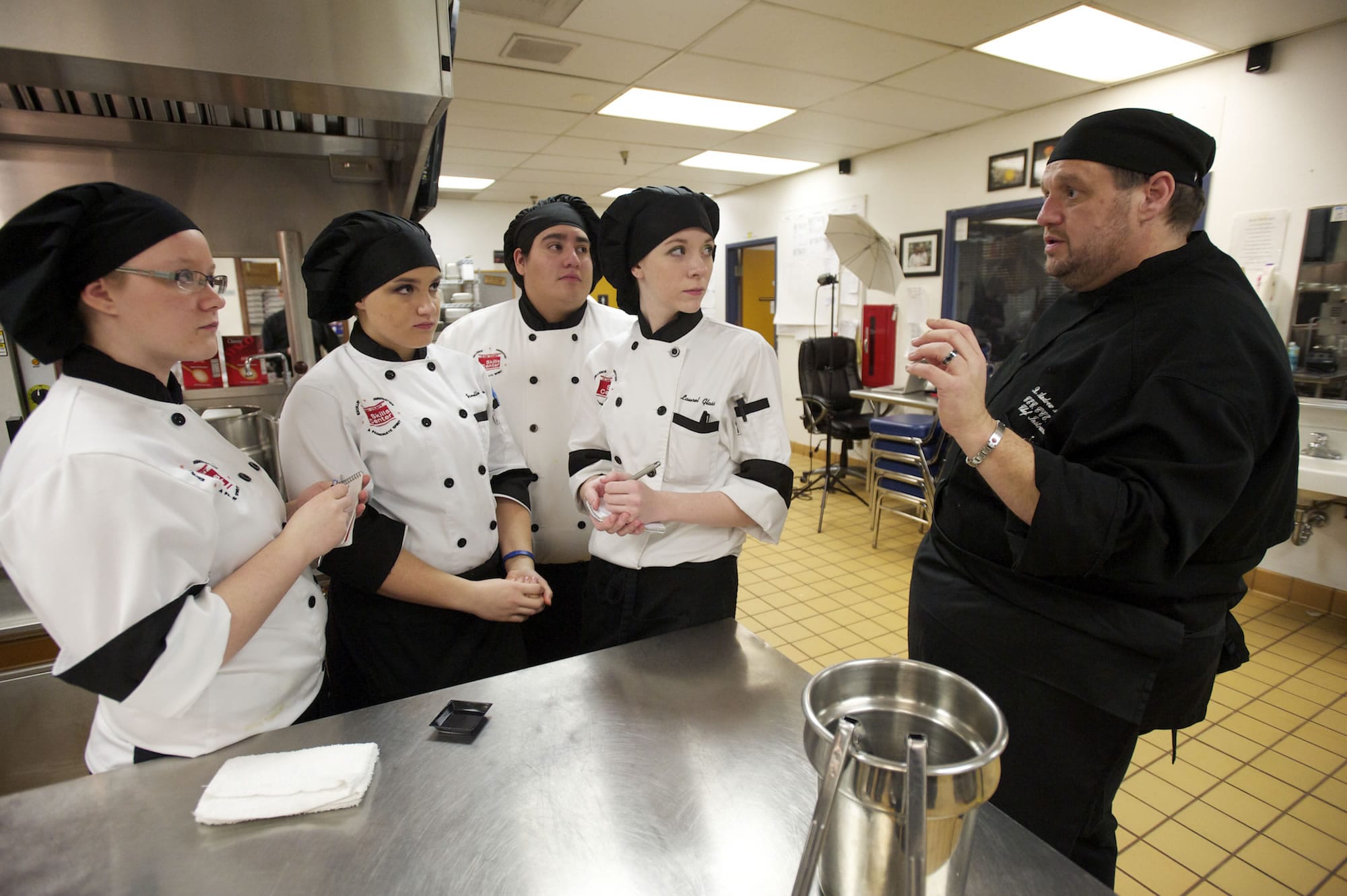 Chef R. Andrew McColley instructs students about the task of preparing 7,500 Washington-inspired hors d'oeuvres. About 30 students and McColley will deliver the food via school bus to Olympia today.