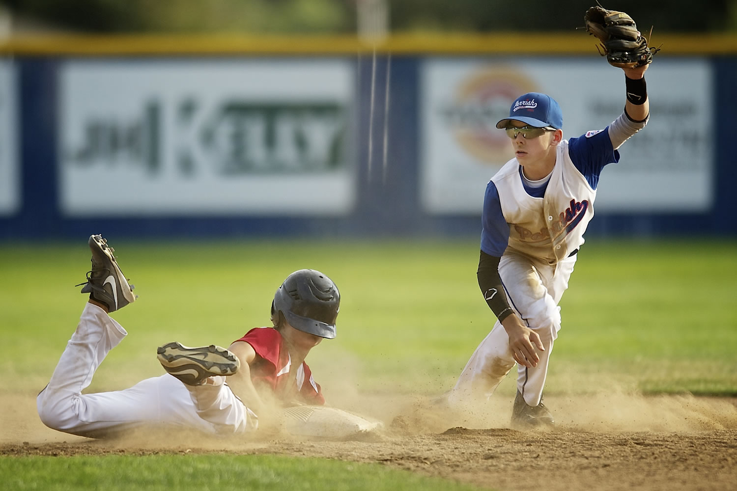 Noah Boatwright, right, of Parrish Little League lifts his glove after recording an out as Josh Mulcahey of Central Vancouver slides into second base.