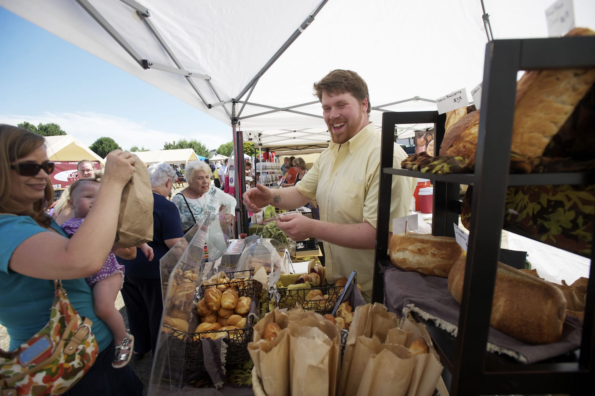 Thomas Pfandler sells baked goods Thursday at the Russell's Bread booth at the Salmon Creek Farmers' Market.