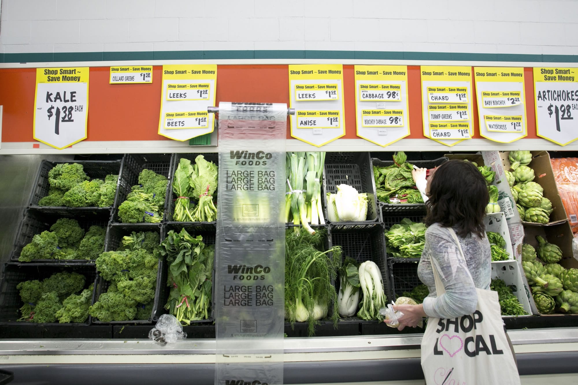 Stasha Hornbeck, a registered dietitian for Kaiser Permanente, checks out the selection of fresh greens at a WinCo Foods store in Portland last week.