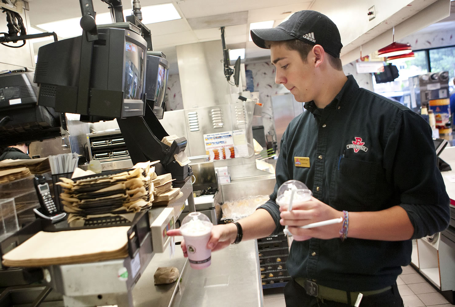 Lucas Schwartz, 17, clears an order before delivering shakes to customers during his shift June 30 at the Central Park Burgerville on East Fourth Plain Boulevard.