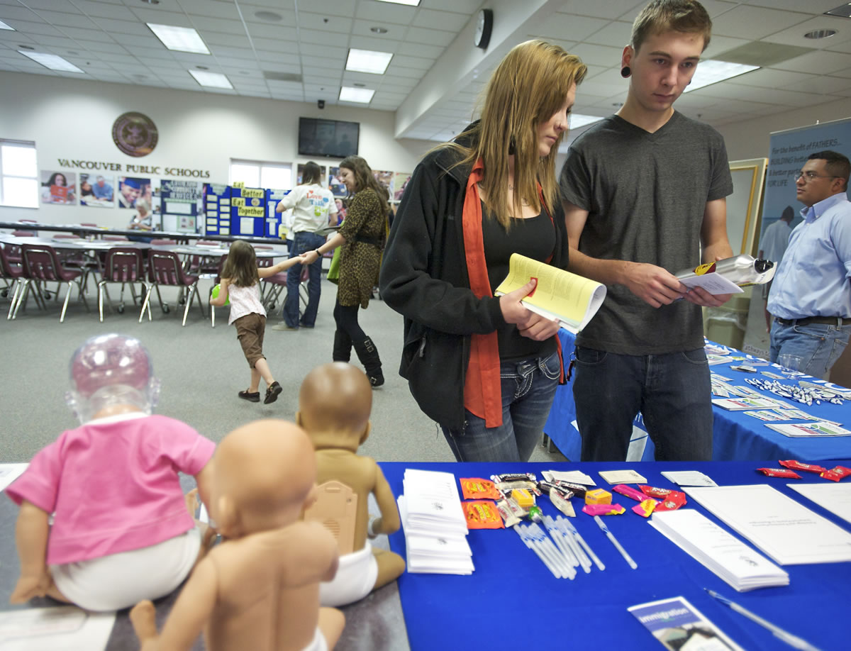 Gabby Swalko, 18, who is about seven weeks pregnant, and her boyfriend, Bryce Hoxeng, 19, gather information Saturday at the teen and young parent resource fair at the Robert C. Bates Center for Education in Vancouver.