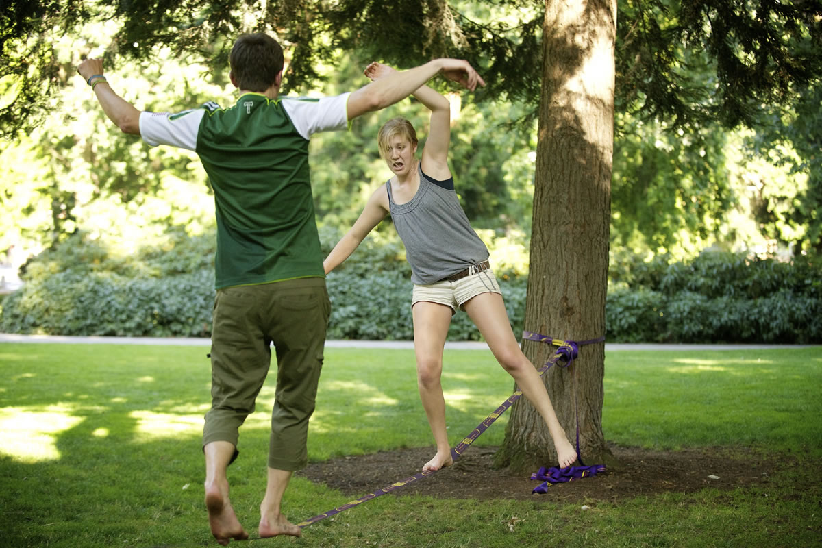Cullen, left, and Lauren Reynolds, 19, of Vancouver, walk toward each other on the slackline, high-five and jump off. The two set up a slackline over water at a dock in Camas on Aug.