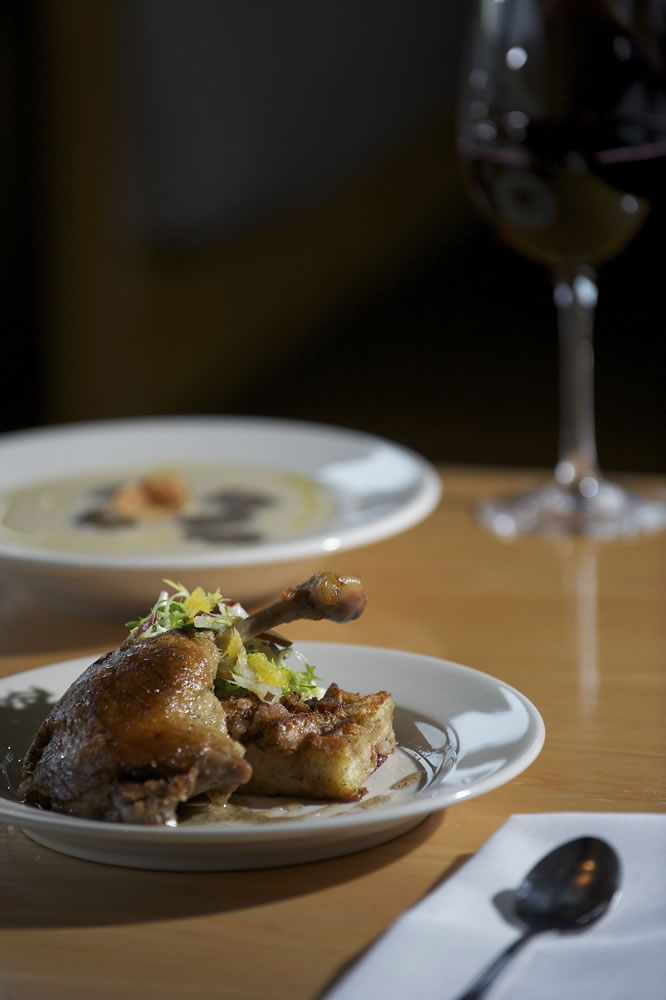 Roots Restaurant's crispy duck confit with cranberry pear bread pudding and cauliflower soup with truffle oil and sunchoke chips.