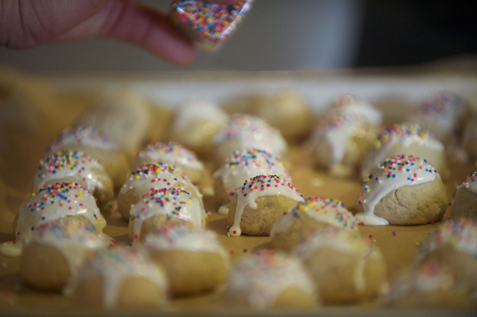 Dena Corso adds sprinkles to a batch of cuccidati cookies at the Vancouver home of Paul and Judy Corso on Saturday.