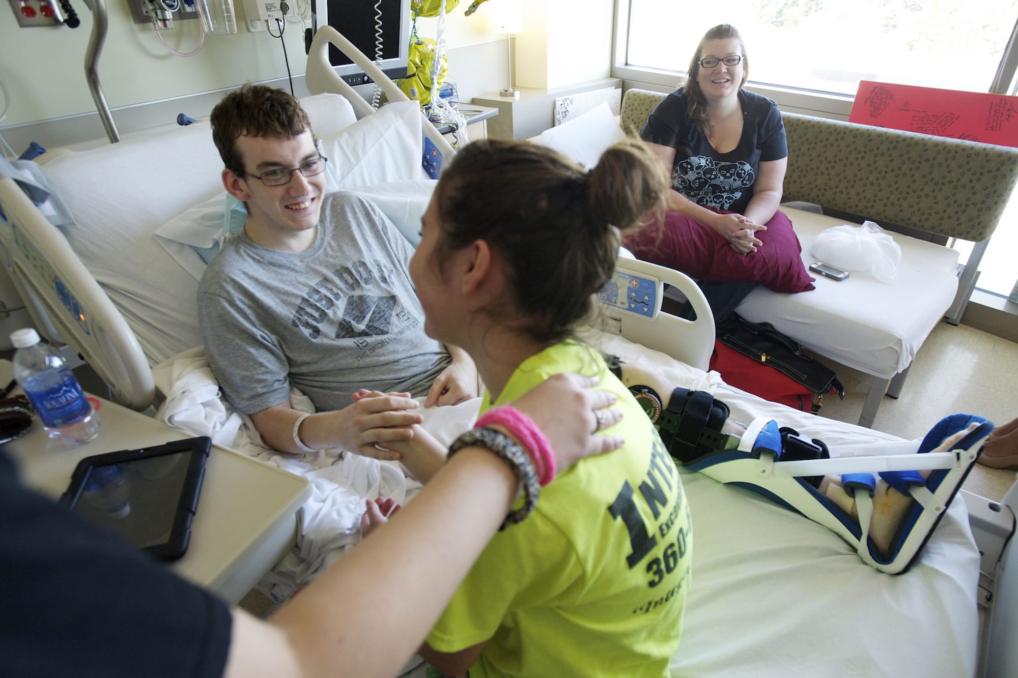 Justin Carey, 16, center, holds hands with girlfriend Lexi Davisson, 14, on July 8 at PeaceHealth Southwest Medical Center.