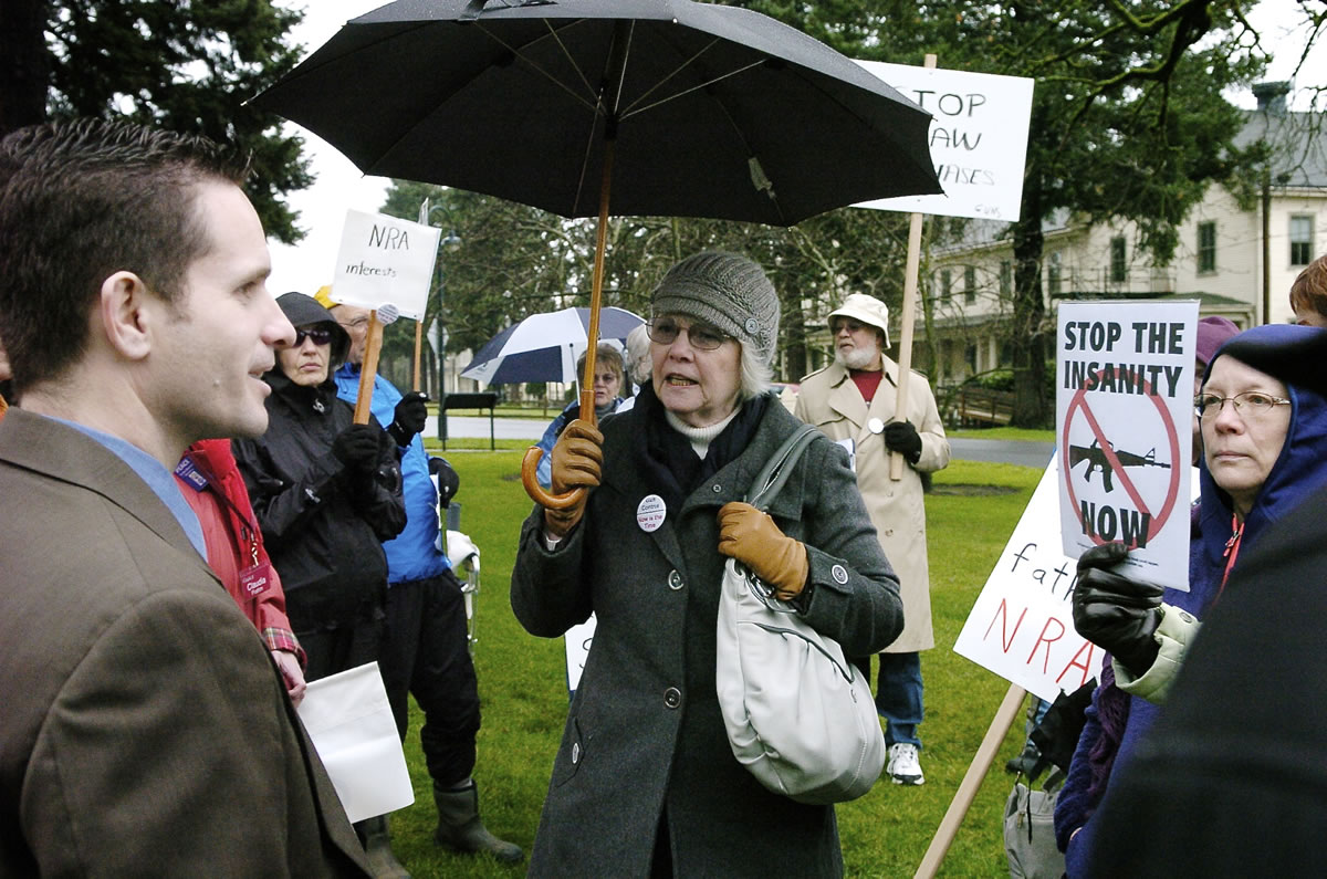 Sandra Hoyt, center, of Vancouver engages Joseph Delli Gatti, right, of Vancouver in a debate about gun control and gun rights during a rally on Tuesday outside the Vancouver office of U.S. Rep.