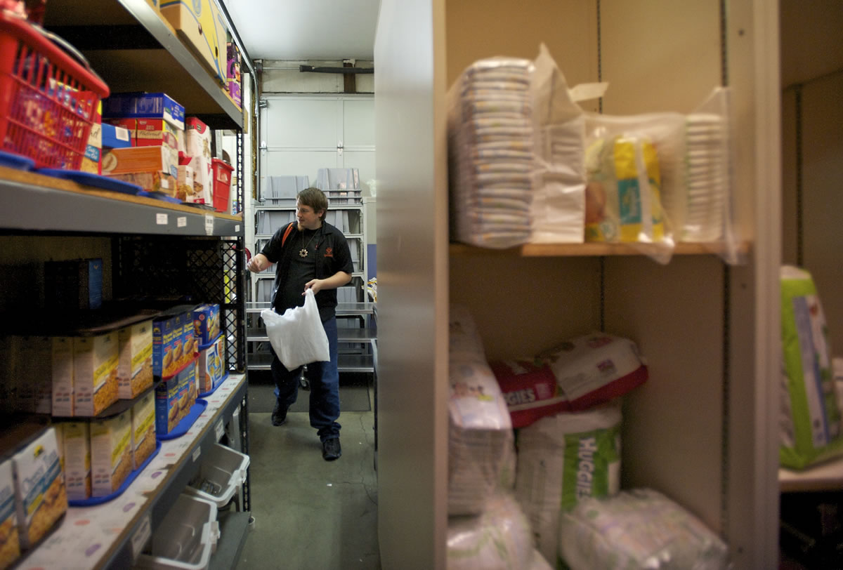Volunteer Tim Reinhold, 26, puts together an order for a client at the North County Community Food Bank in its storeroom.