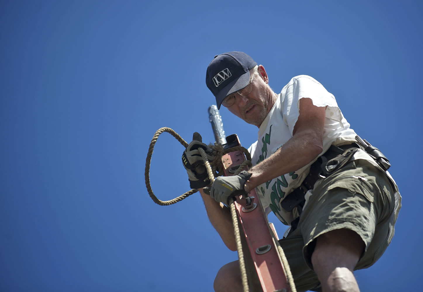 At left, Rich Ullsmith of Camas hauls up a new assembly for the top of Pam McNamara's flagpole.