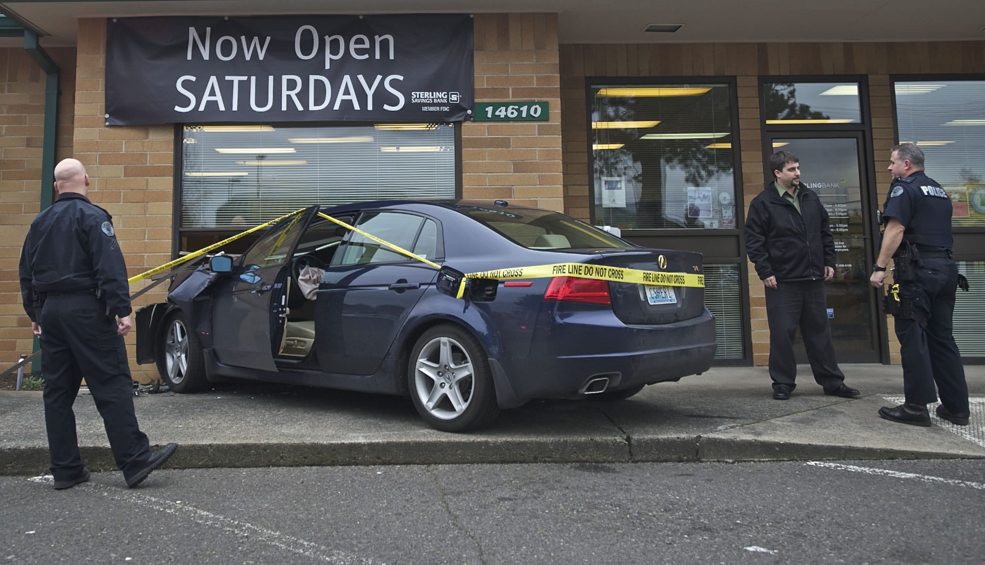 Police speak to the manager of Sterling Savings after a woman accidently drove her car through the window Wednesday afternoon.