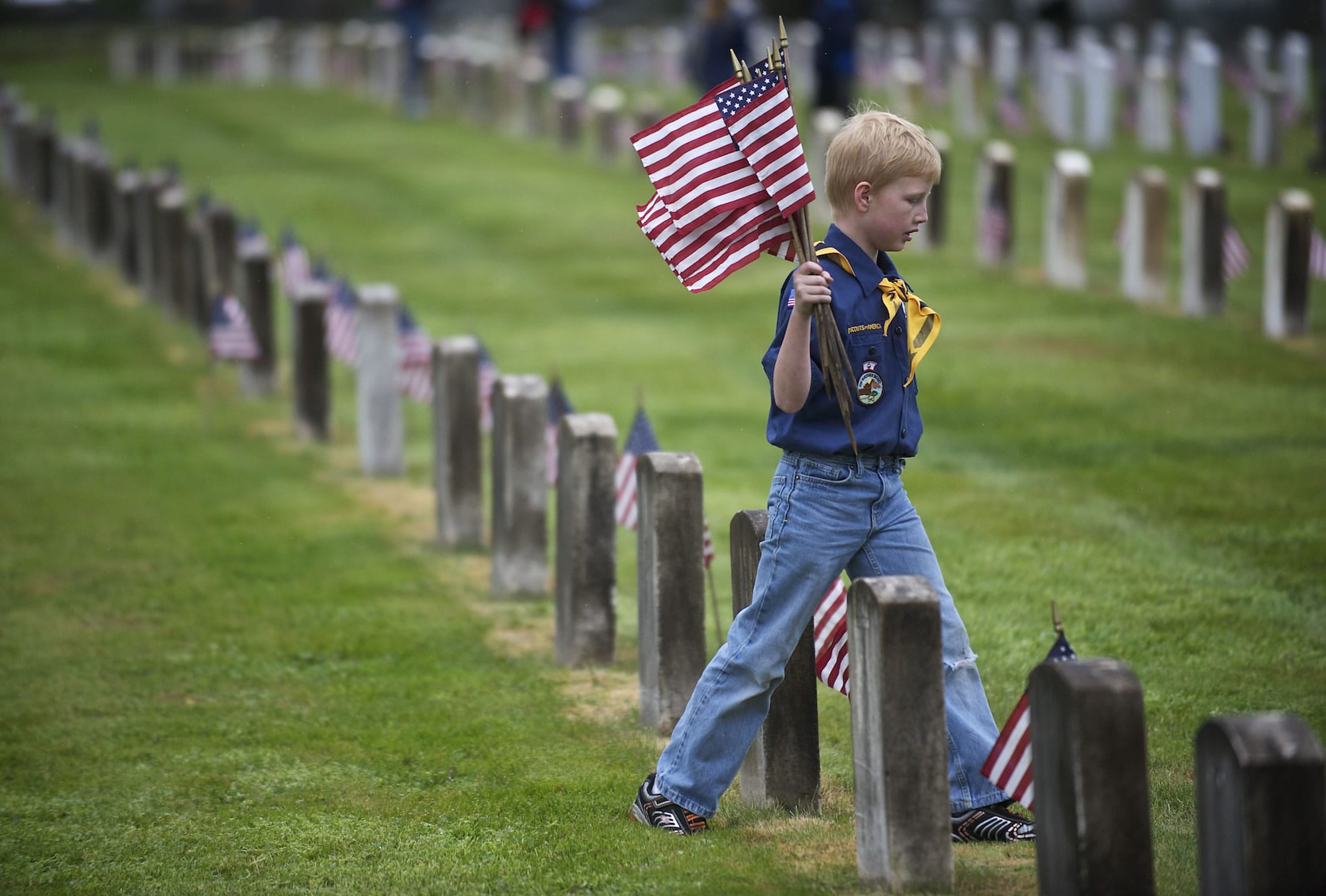 Ryan Nelson, 8, of Ridgefield, and other Cub Scouts from Pack 637 placed flags on the graves of veterans Thursday at the Post Cemetery.
