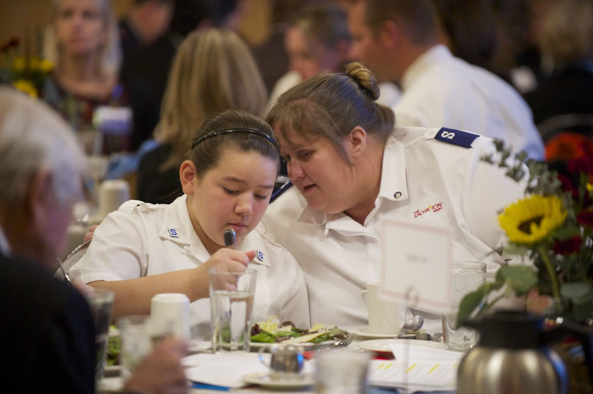 Time-tested Salvation Army client and volunteer Jackie Varner Hilby, right, chats with 11-year-old Kateresa Rowe during the charity's annual community luncheon at the Heathman Lodge on Wednesday.