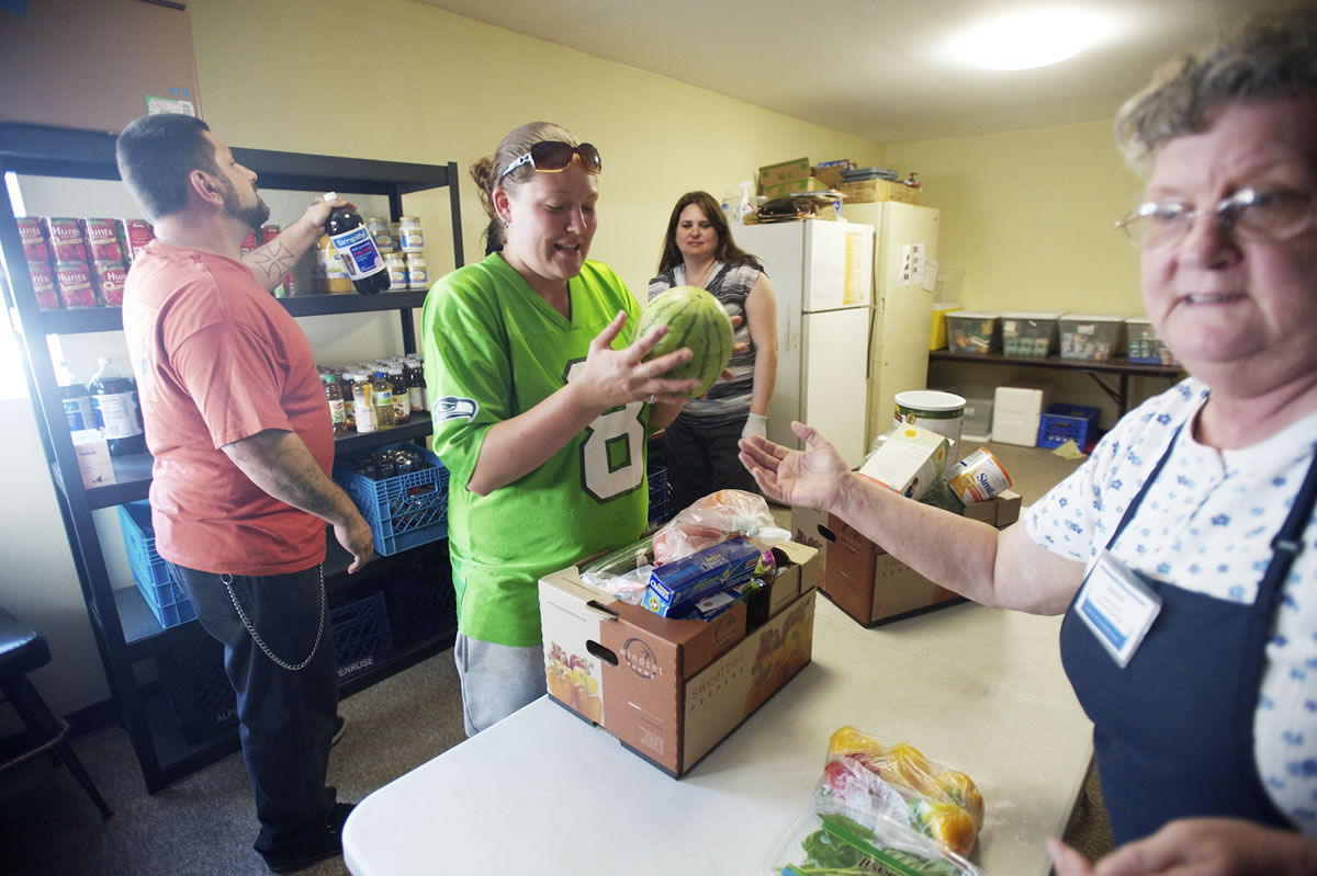 Heather Johnson, 23, of Vancouver picks up groceries at the River of Life Foursquare Church food bank on a Wednesday afternoon in June.