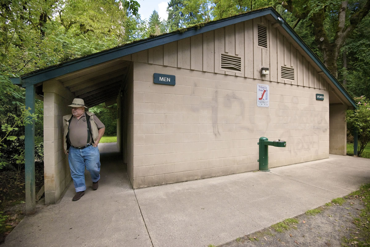 Hal Bauder, Clark County parks maintenance crew chief at Lewisville Park, examines a restroom damaged by vandals in June.