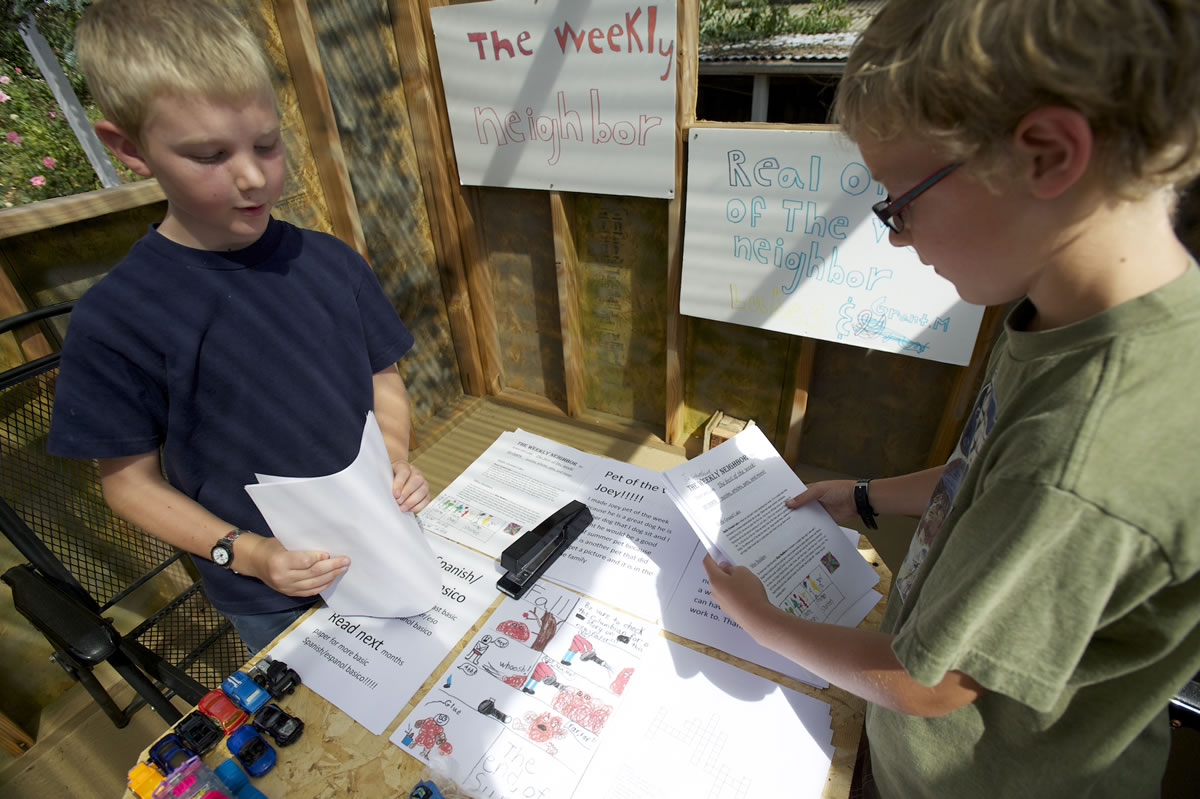 Photos by Steven Lane/The Columbian
Grant Myers, left, and Luke Seeley, both 9, assemble the final summer edition of The Weekly Neighbor, their homemade newspaper covering the Father Blanchet Park neighborhood. The Weekly Neighbor's newsroom is this clubhouse in Seeley's backyard.