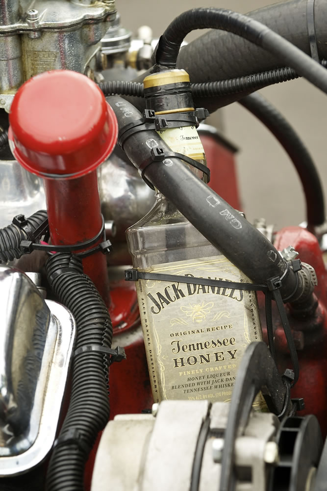 A Jack Daniel's bottle catches radiatior overflow.