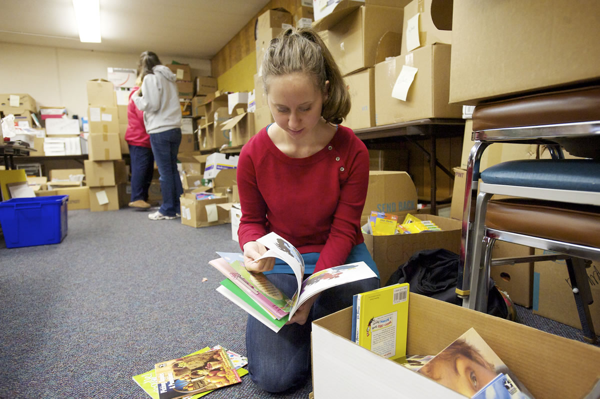 Crestline Elementary first-grade teacher Zoe Fromer sorts through donated books and school supplies Saturday at the Evergreen Public Schools administrative offices.Inside: Information on how to make a donation.