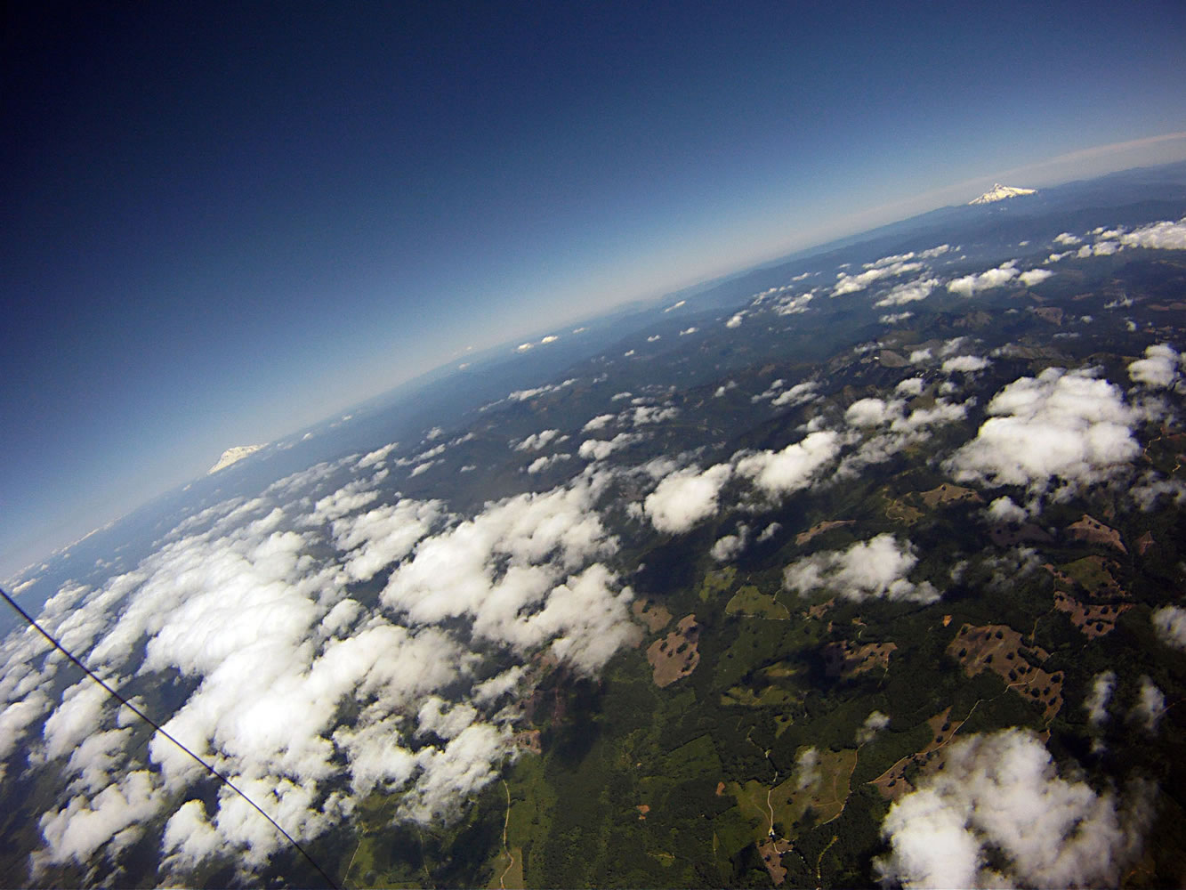 An image from a camera aboard a balloon cluster shows Mount Adams, from left, and Mount Hood from an altitude of about 13,000 feet.