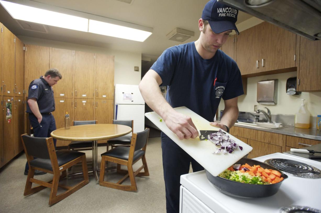Vancouver first-year firefighter Isaac Eldred prepares coconut curry chicken for dinner at Station 2 in west Vancouver on March 1.