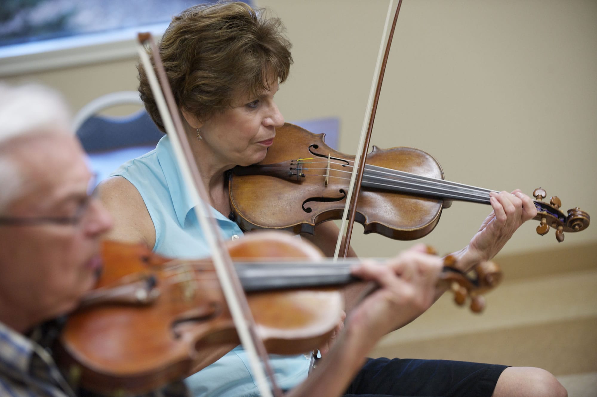 Violinists Bob Pforsich, from left, and Kathy Barry rehearse at Fairway Village.