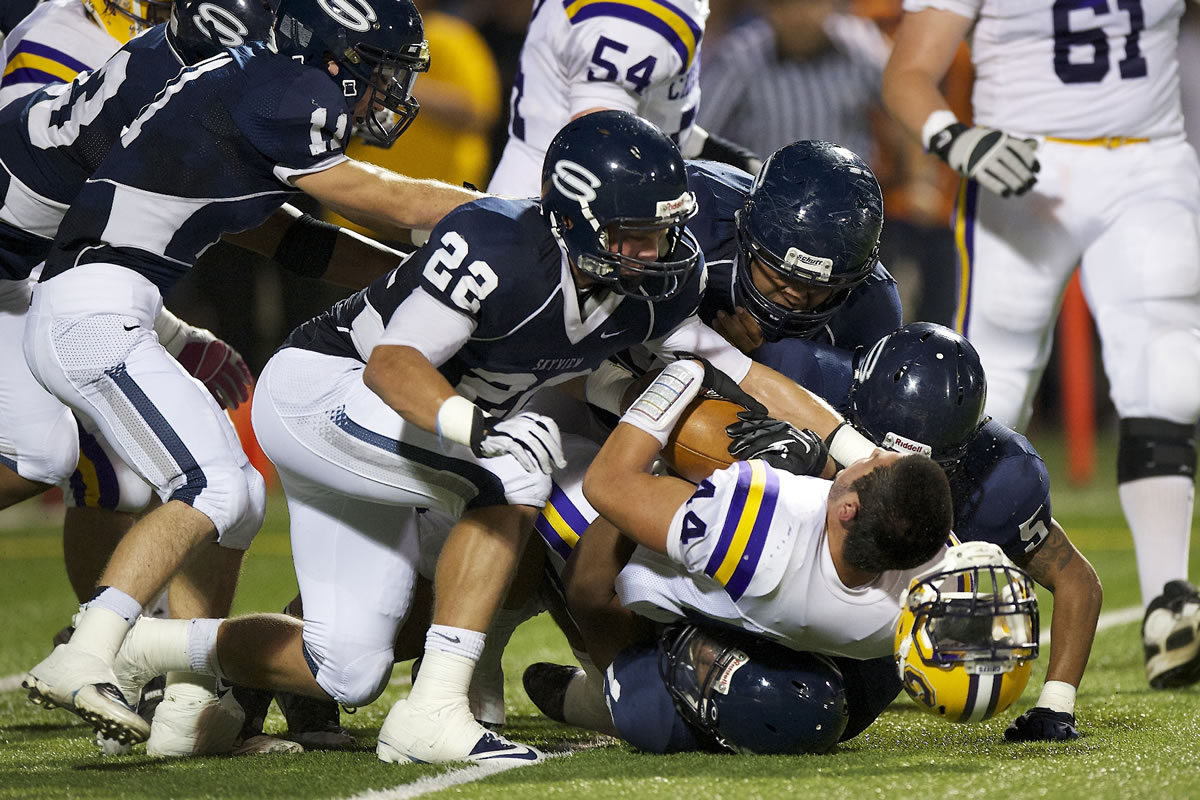 Skyview's defense smothers Columbia River's Remick Kawawaki (44), who loses his helmet but not the ball Friday.
