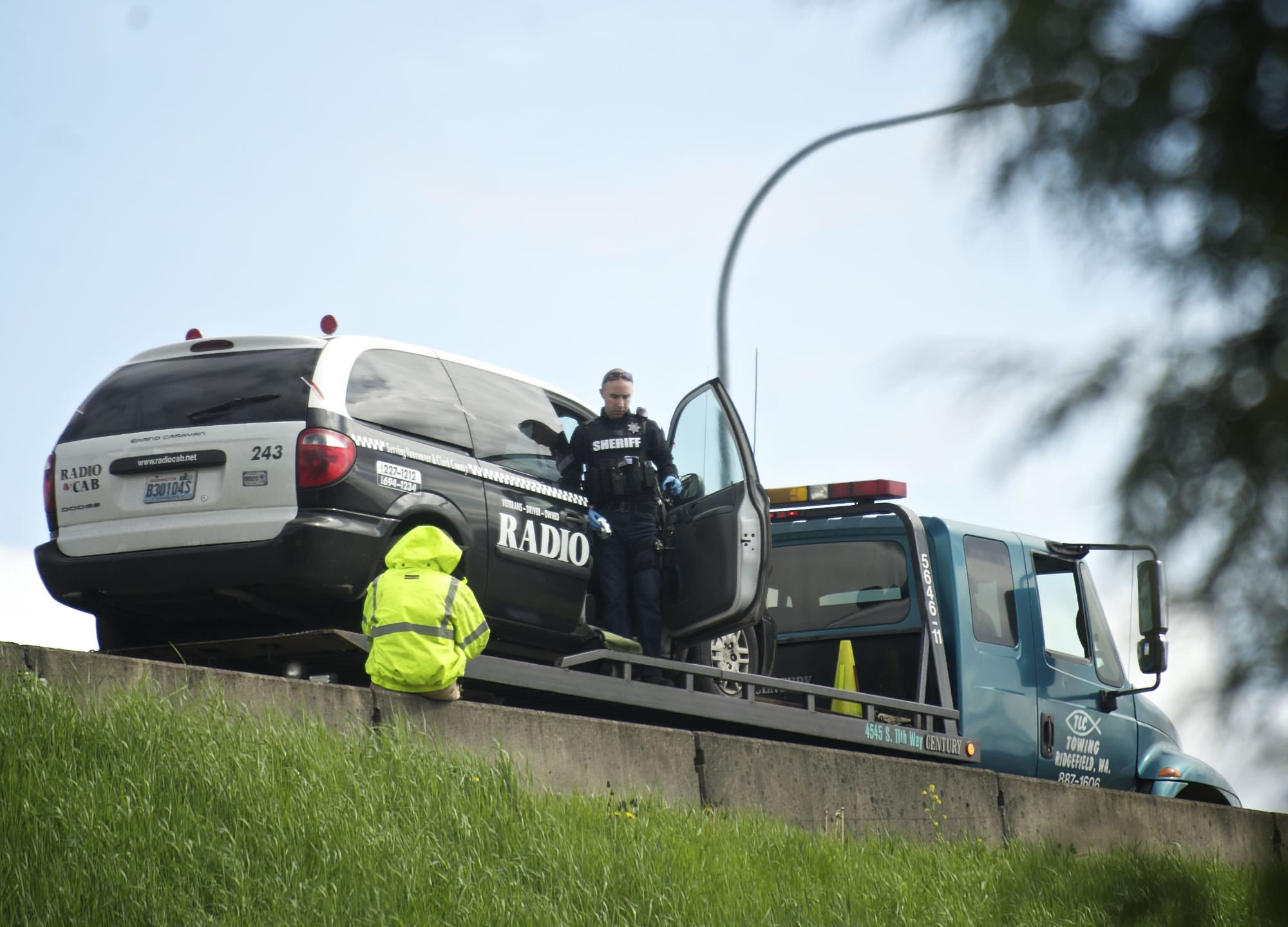 A Clark County Sheriff's deputy exits a taxi cab on the southbound shoulder of Interstate 5 just north of the 78th Street exit, which was allegedly used as the getaway car in the robbery of the IQ Credit Union on Thursday.