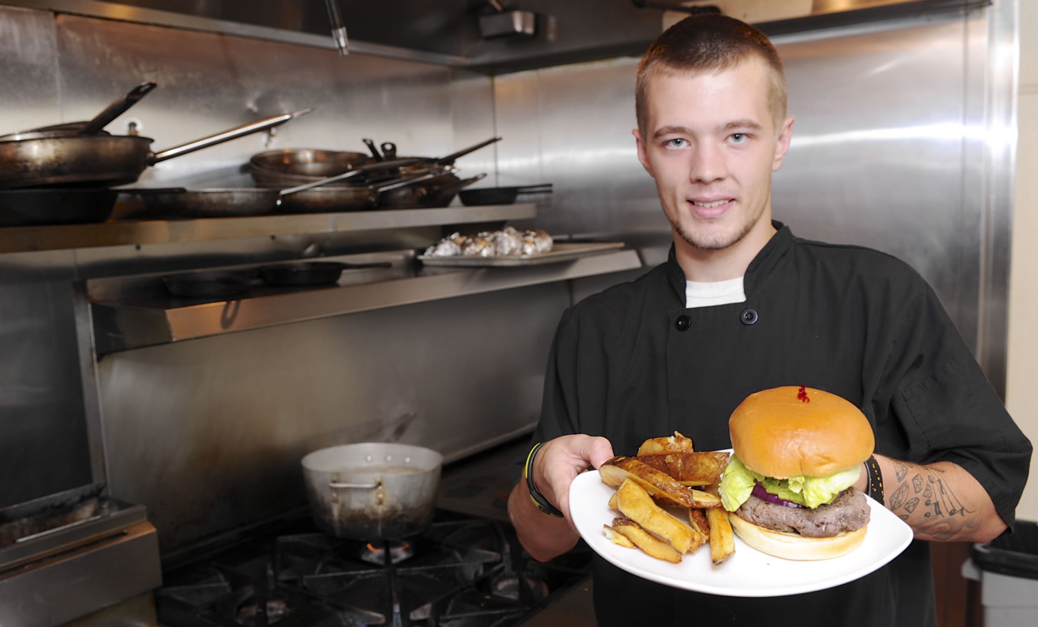 Austin Theroux displays a kangaroo burger in the kitchen at Bone's restaurant in Battle Ground.