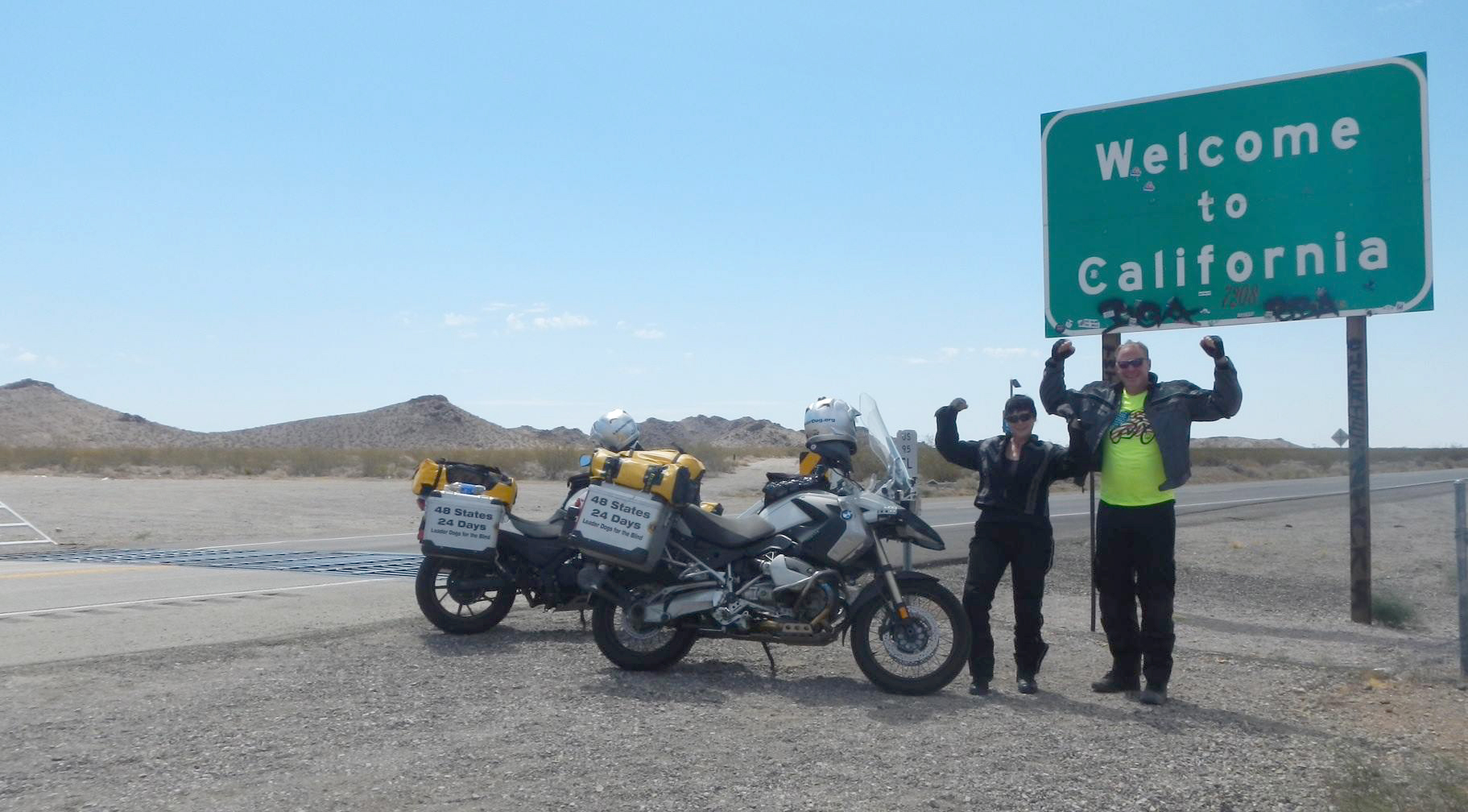 La Center: La Center Lions Club members Mark and Debbie Mansell rest on July 8 at the California state line near the end of a U.S. motorcycle tour that took them across 48 states in 24 days.