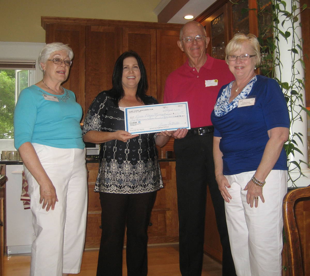 Esther Short: Newcomers Club members Gladys Green, left, and Karen Roark, far right, present a check to Dawn Barton and Michael Bacon of Open House Ministries.