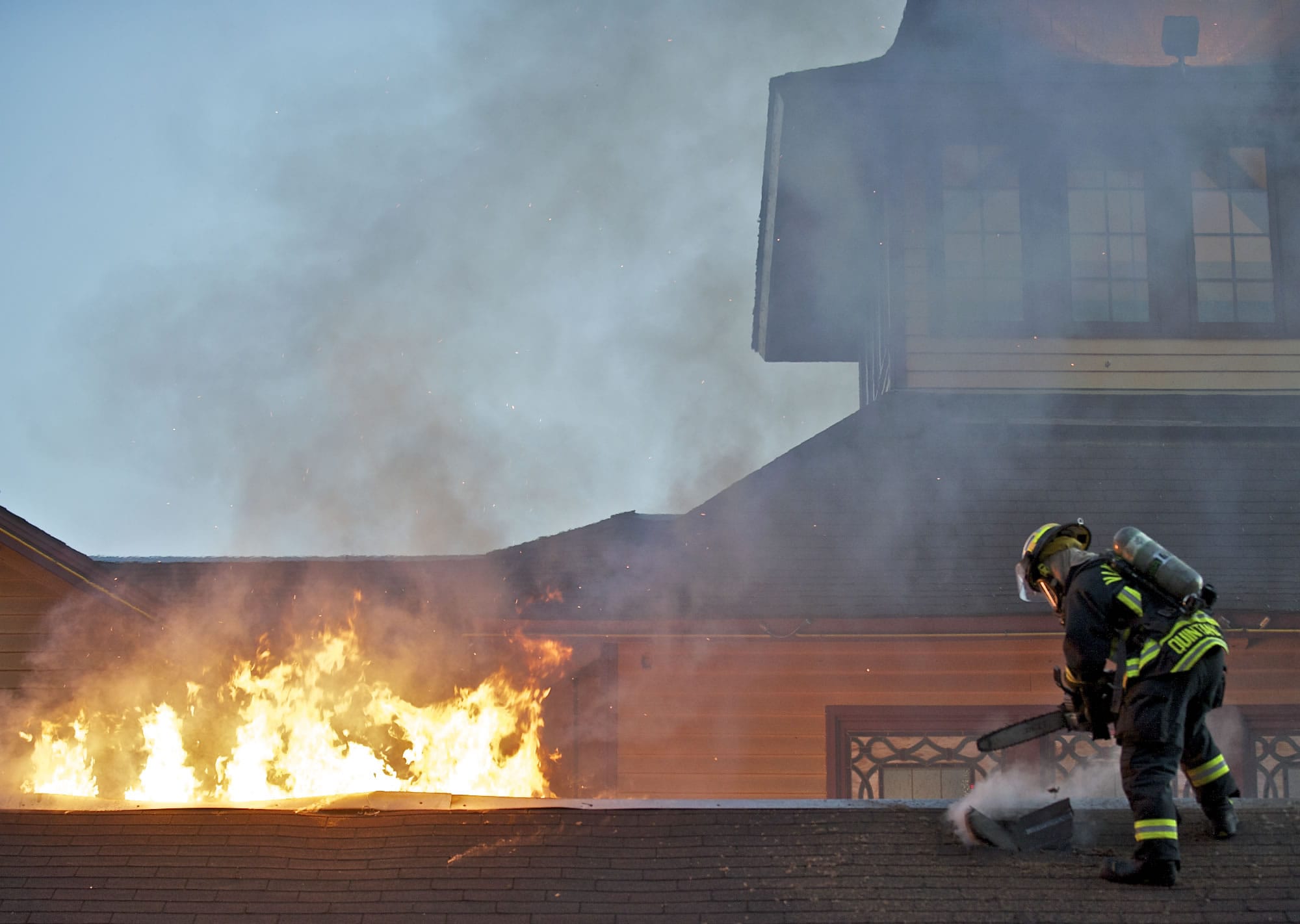 A Vancouver firefighter cuts a hole in the roof of Who Song and Larry's restaurant on Wednesday.